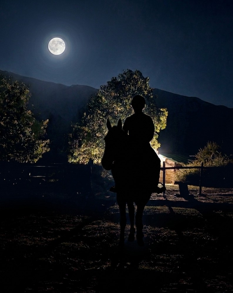 Silueta de un jinete a caballo bajo la luna llena en una lunada en Riaza