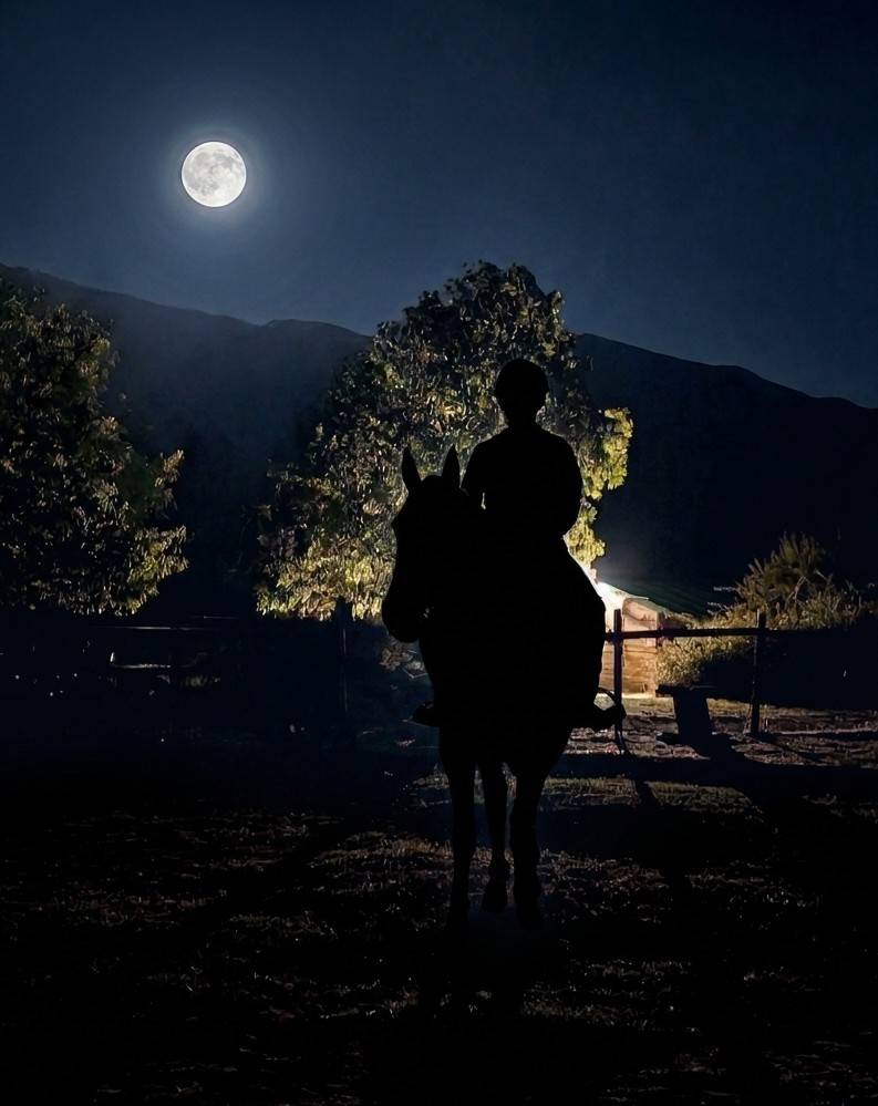 Silueta de un jinete a caballo bajo la luna llena en una lunada en Riaza